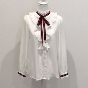 White ruffled blouse with Navy and Red ribbon.